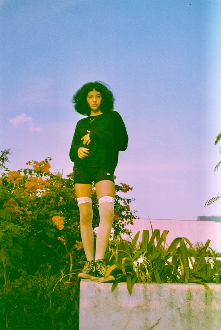 Photo Of A Woman Standing On A Wall And Wearing White Stockings And Black Sneakers