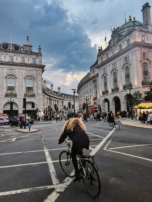 Free A cyclist navigates Regent Street in London with historical buildings and bustling city life. Stock Photo