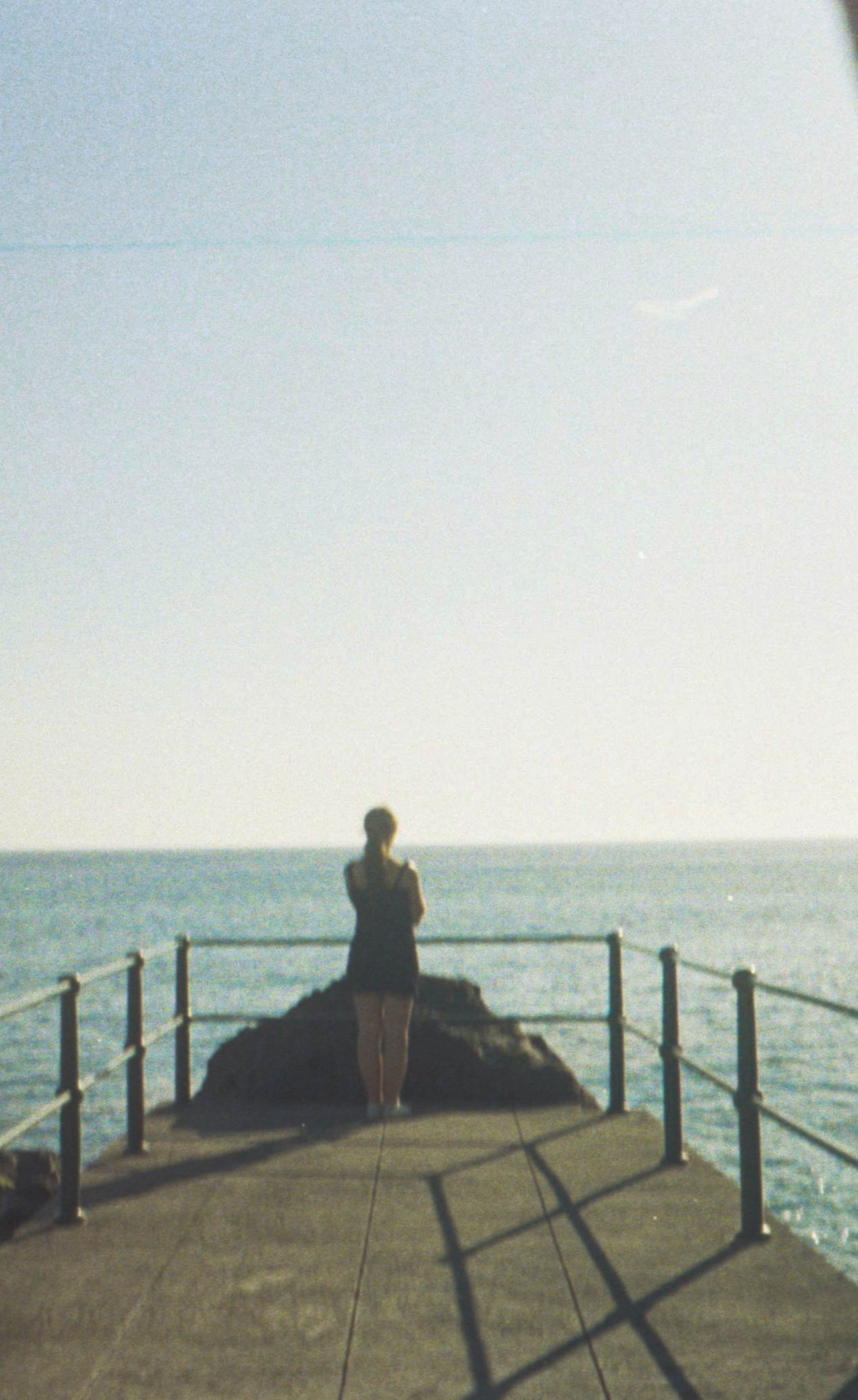 A Woman Standing on a Pier · Free Stock Photo