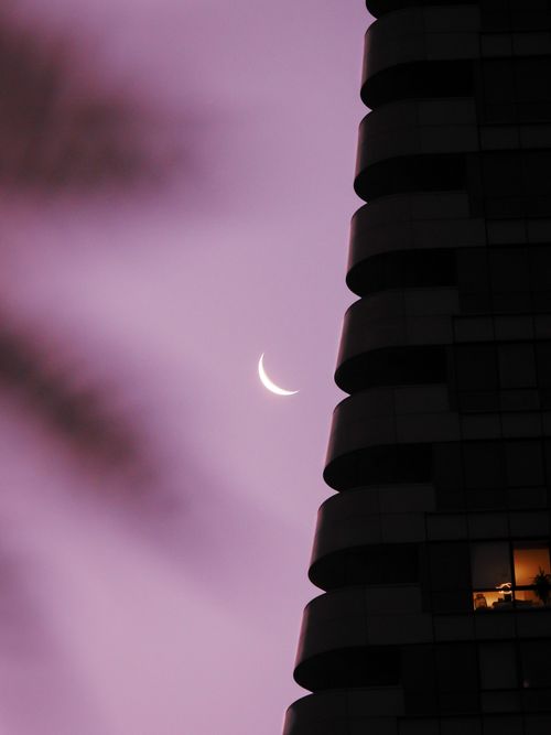 Free Crescent moon beside Istanbul's modern skyline during dusk with a purple sky background. Stock Photo