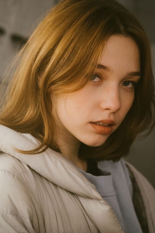 Free Intimate portrait of a young woman with long hair in a soft, warm light. Stock Photo