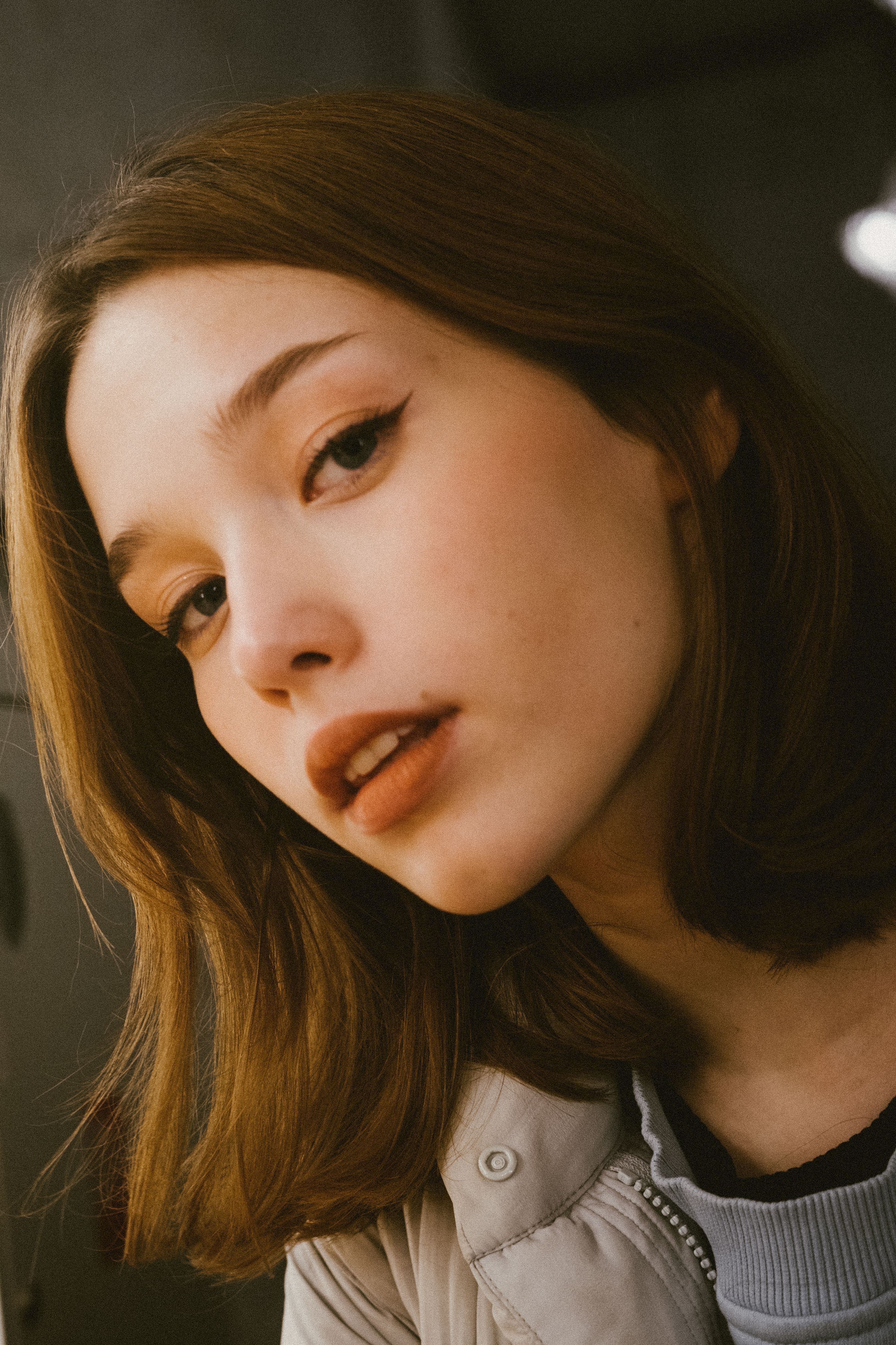 A stylish close-up portrait of a young woman with a thoughtful expression.