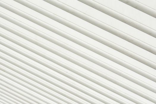 Abstract view of white aligned metal tubes creating a geometric pattern, ideal for design projects.