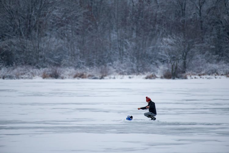 Person Fishing On A Frozen Lake