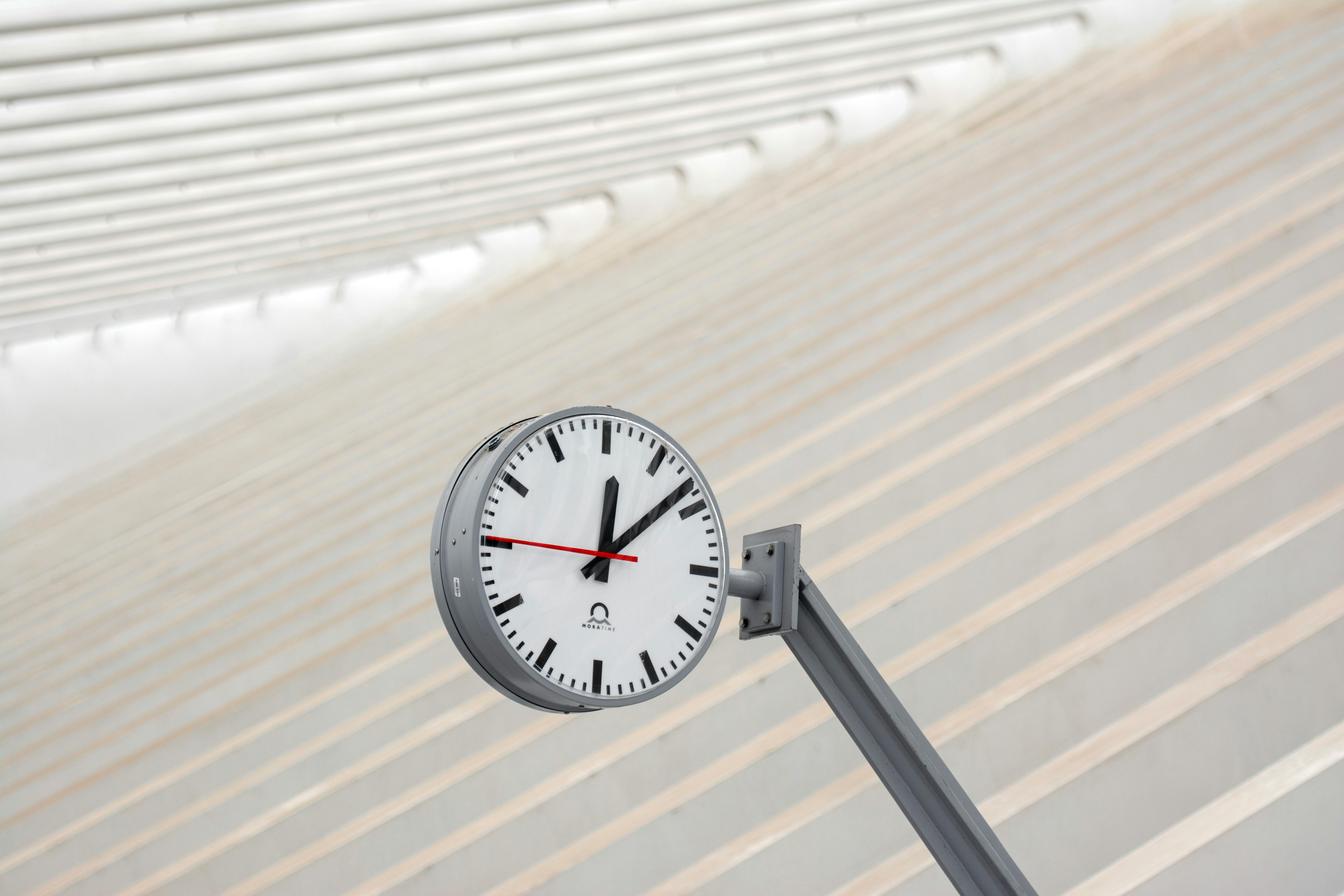 Low angle view of a station clock against a modern architectural background in Liège.