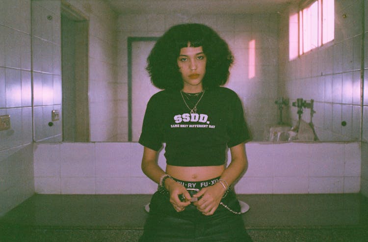 Photo Of A Young Woman Leaning On The Sink In The Public Restroom