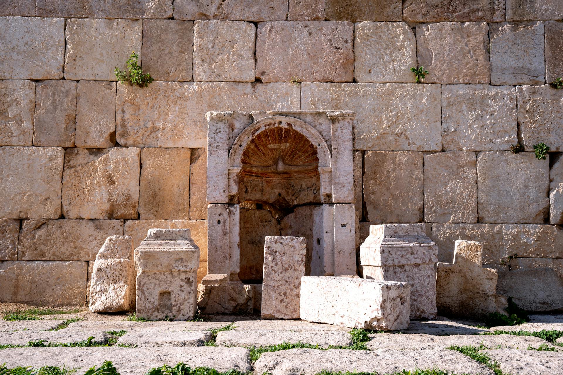 Ancient Roman wall and fountain in Jerash, showcasing archeological architecture.