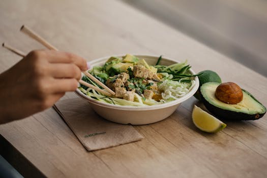 Delicious tofu salad with avocado and zucchini noodles on wooden table. Perfect for health-conscious food lovers.