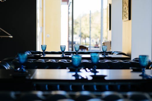 Blue glass goblets set on tables in a chic restaurant interior showcasing modern decor.