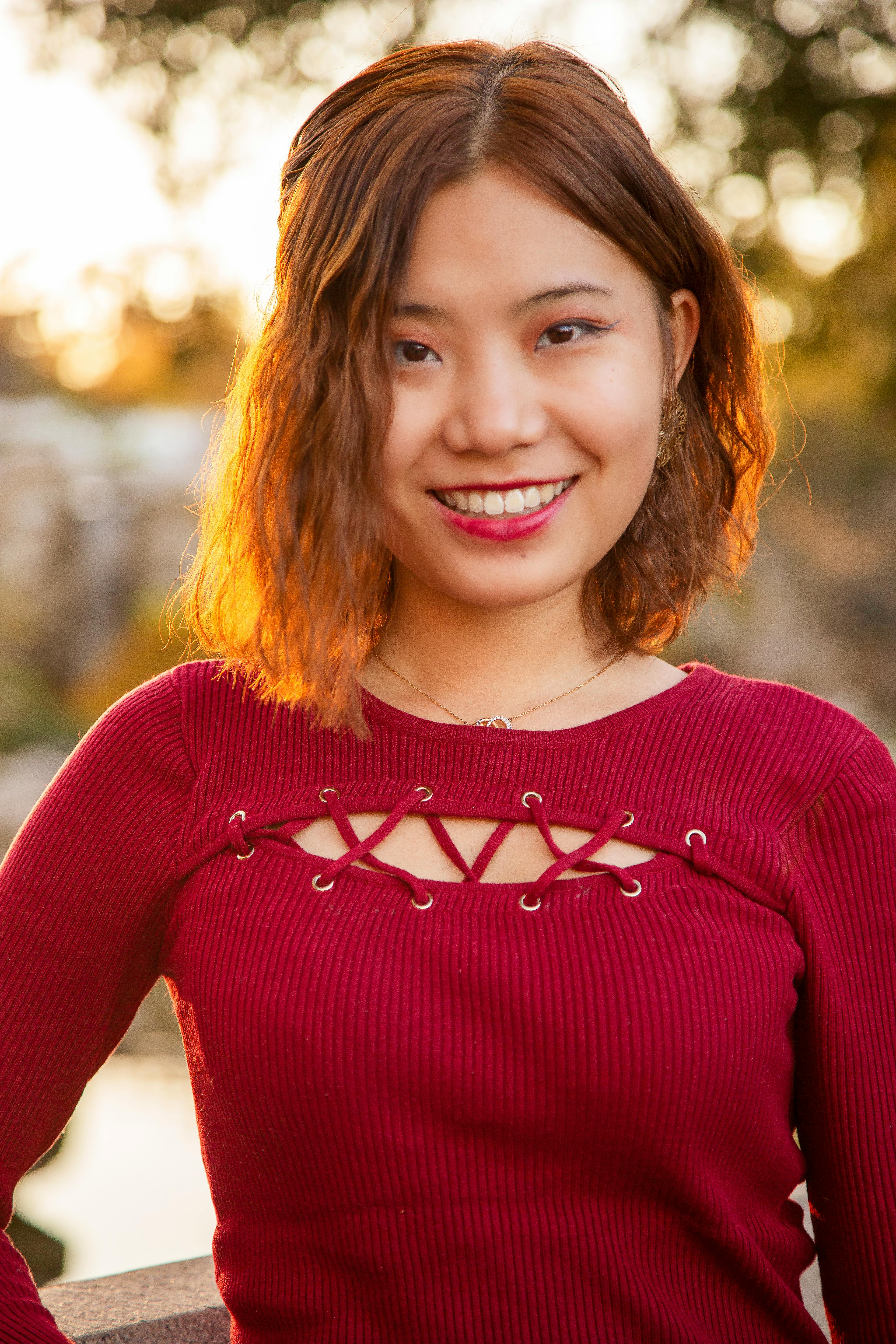 Portrait of a smiling woman with brown hair in a red top during sunset in Los Angeles.