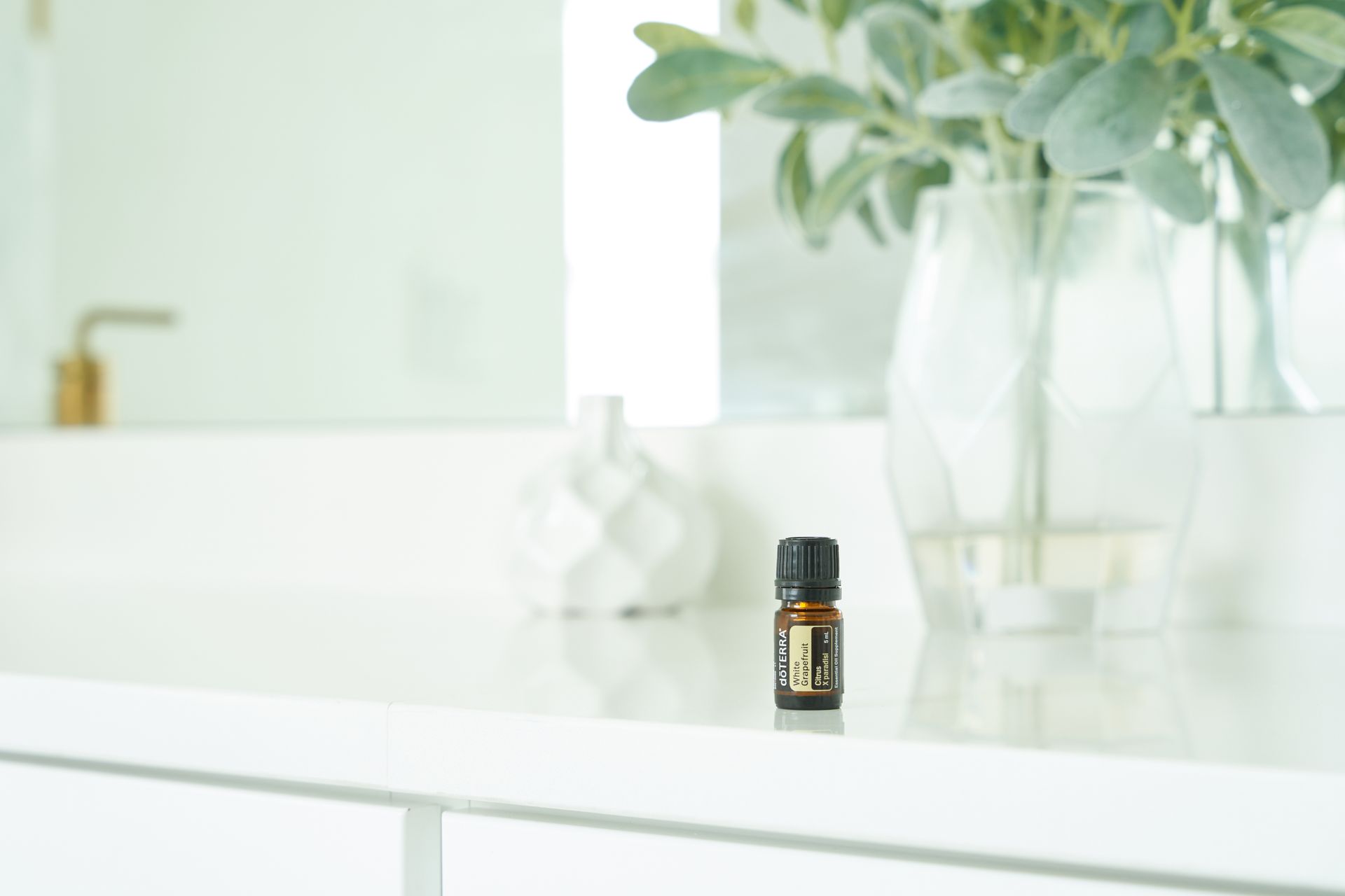 Close-Up Shot of an Essential Oil Bottle on White Surface