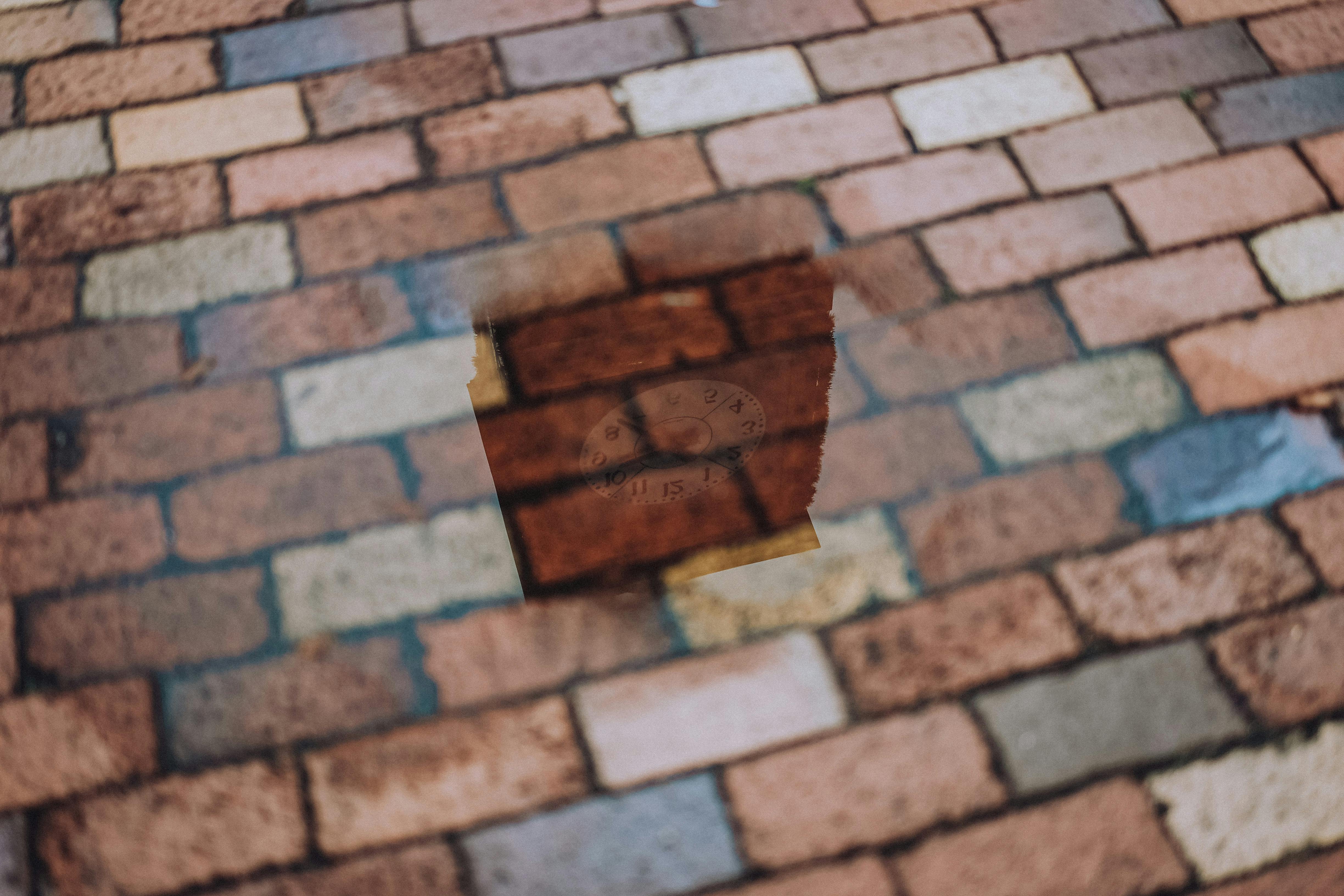 Reflection of a Tower in a Puddle on a Pavement · Free Stock Photo