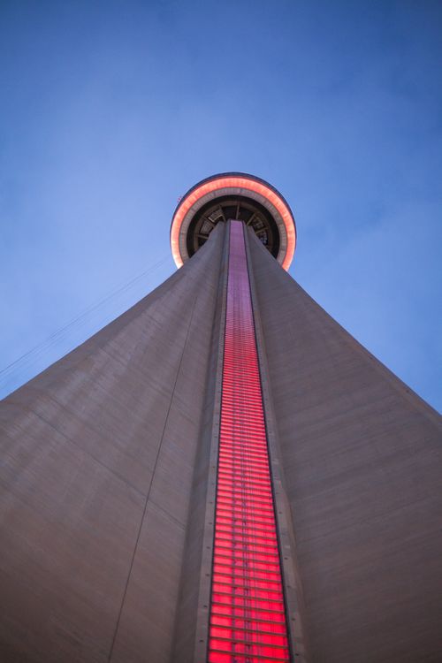 Free Striking view of the CN Tower with red illumination against a twilight sky. Stock Photo