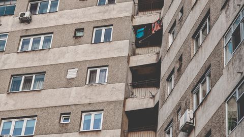 High-rise residential building with balconies and multiple windows in an urban setting.