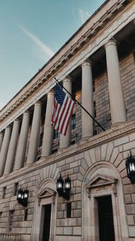 A majestic neoclassical building with the US flag, showcasing Washington DC's architectural heritage.