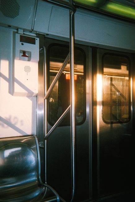 Subway interior with sunlight casting warm reflections on metallic surfaces in Mexico City.