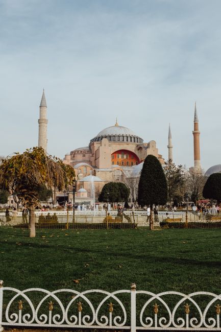 View of Hagia Sophia in Istanbul with surrounding lush park and blue sky.