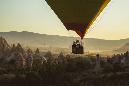 Majestic hot air balloon ride over Cappadocia's iconic rock formations at sunset.