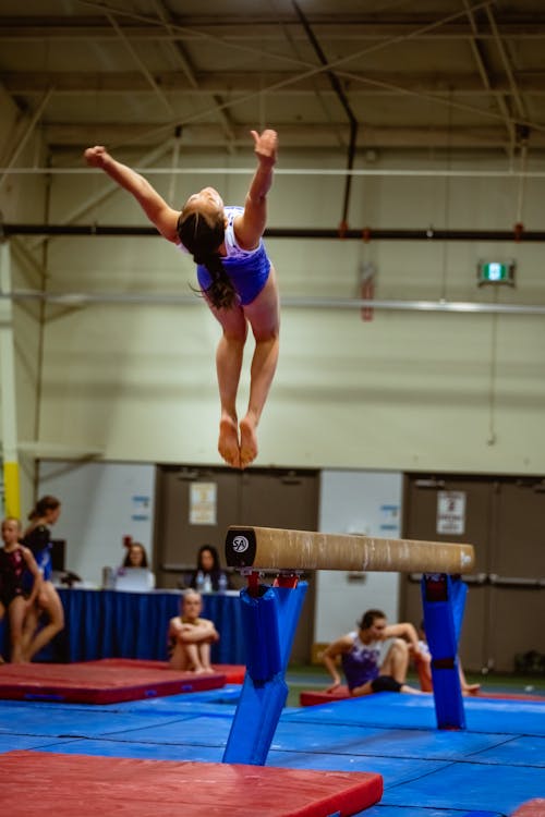 Girl Gymnast Jumping on Beam