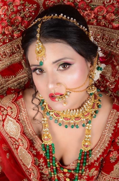 Free Close-up of an Indian bride wearing traditional red attire and ornate jewelry. Stock Photo