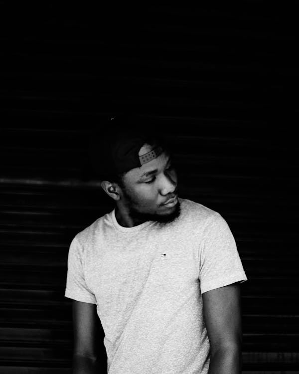 Grayscale Photo of Man Wearing Snapback Cap