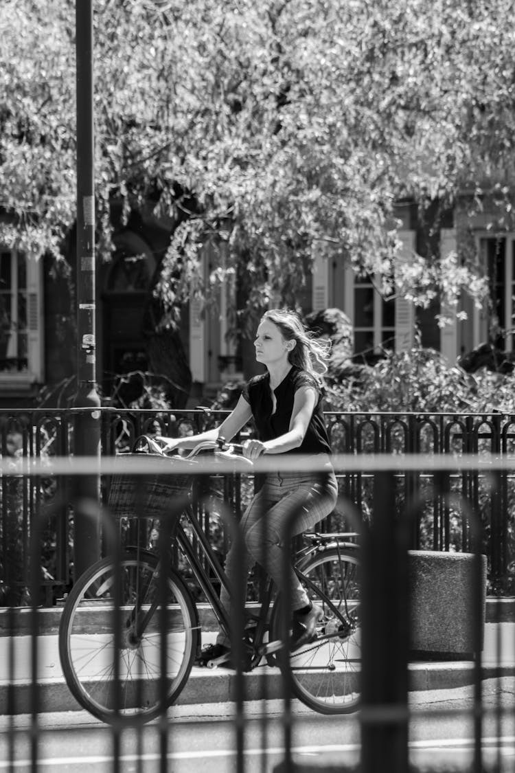 A Woman Riding A Bicycle On The Street