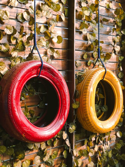 Free Red and Yellow Tires Hanging on Wood Fence  Stock Photo
