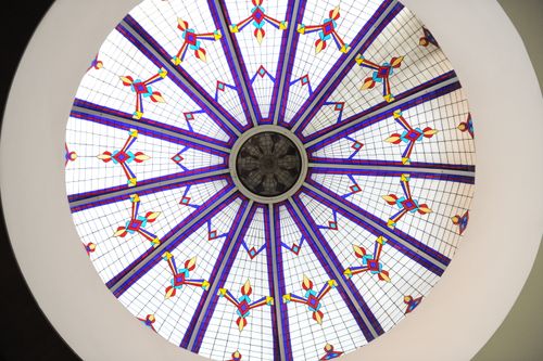 Free Geometric stained glass dome ceiling with vibrant colors, viewed from below. Stock Photo