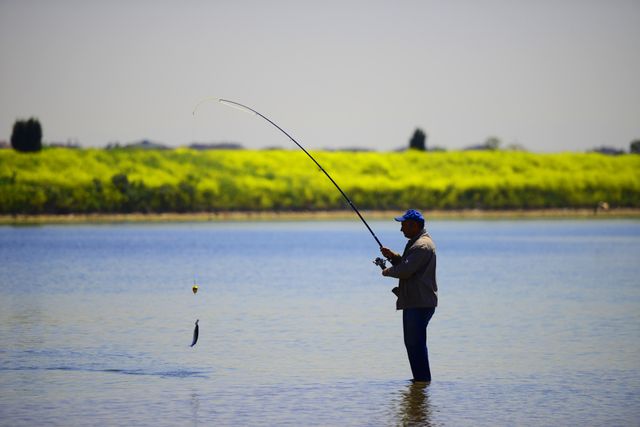 Angler wading mid-river with a bent fly rod