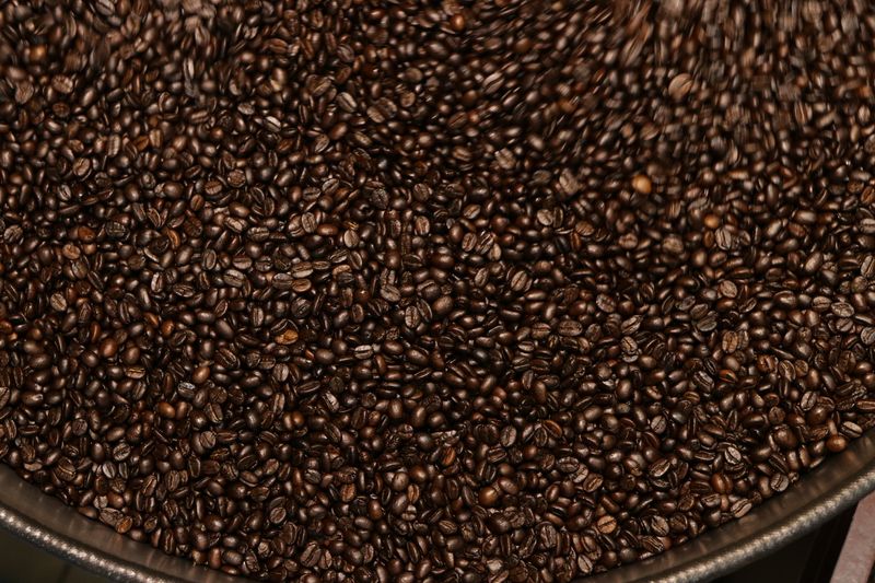 Close view of dark roasted coffee beans filling a container