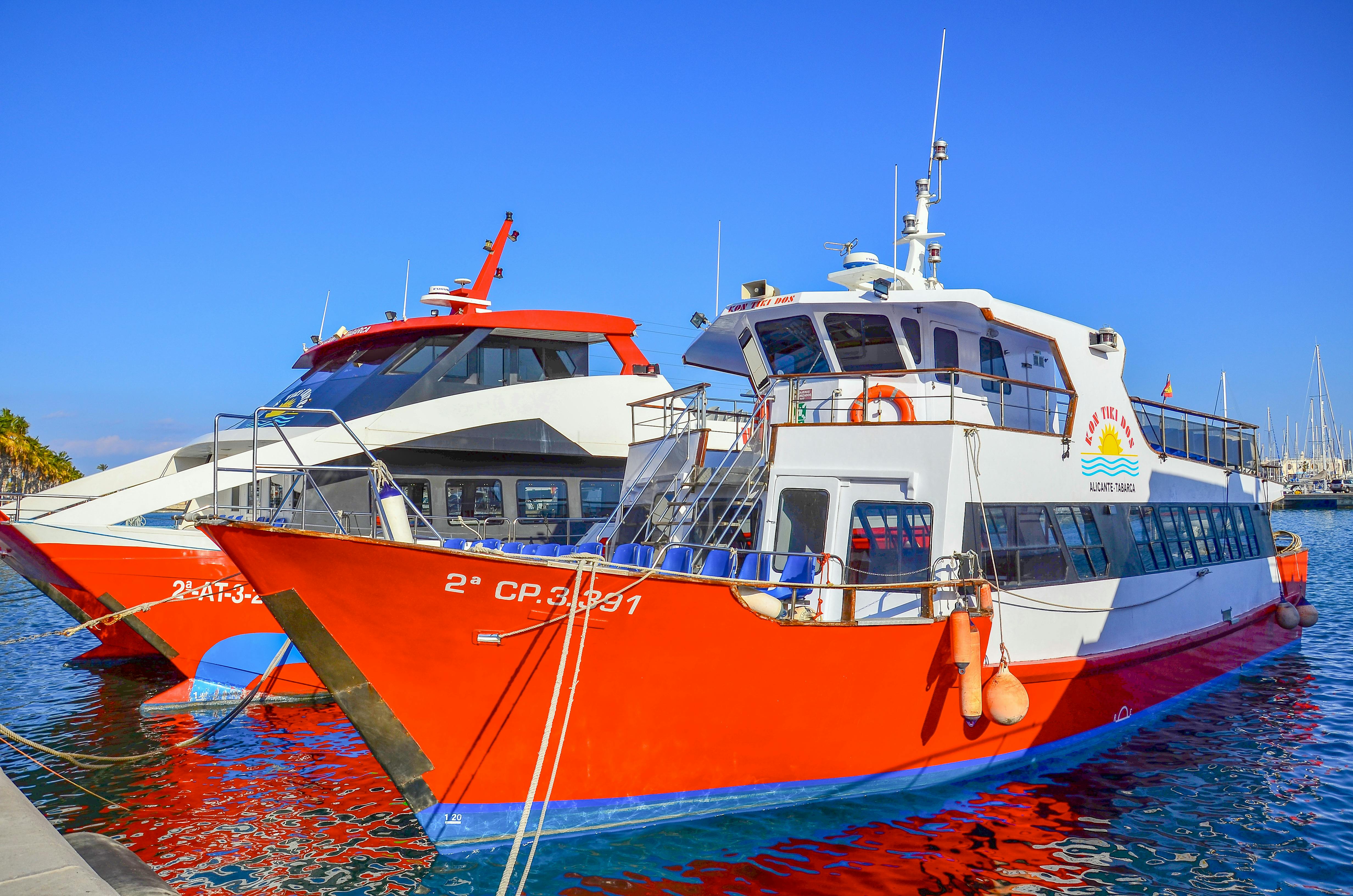 Free Vivid red and white passenger boats docked at a sunny marina under a blue sky. Stock Photo