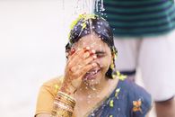 Woman Wearing Black and Brown Dress While Water Splashing on Her