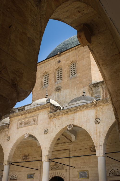 Free A beautiful mosque courtyard featuring a dome and arches, reflecting Islamic architecture. Stock Photo