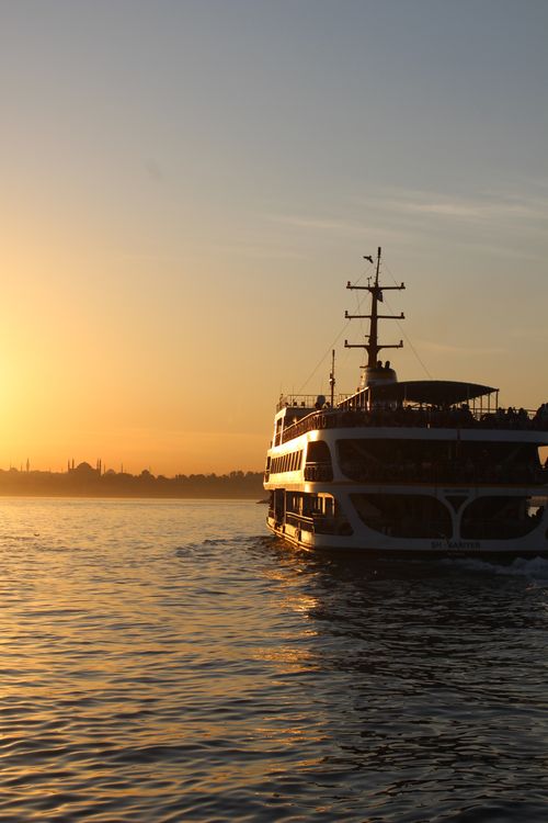 Free A ferry makes its way across the Bosphorus Strait during a stunning sunset, capturing Istanbul's beauty. Stock Photo
