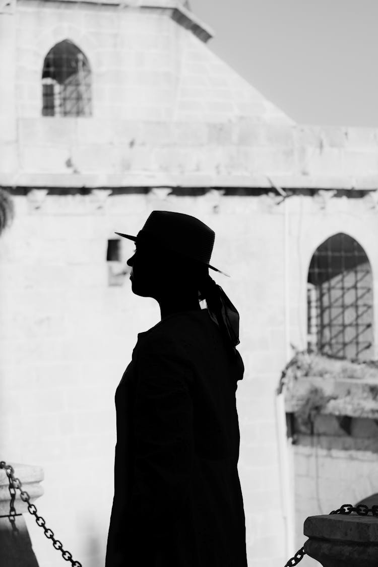 A Silhouette Of A Woman Wearing A Hat