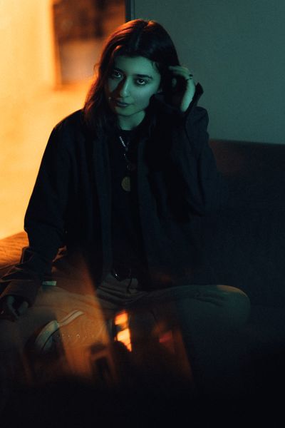 Portrait lit by warm and cool light in a dark room, photo by Atahan Demir on Pexels