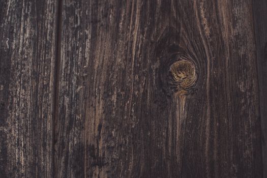 Detailed view of a dark wooden surface showcasing natural grain patterns and rich, earthy tones.