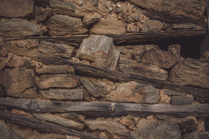 Detailed view of a textured stone and wood wall showcasing natural rustic materials.