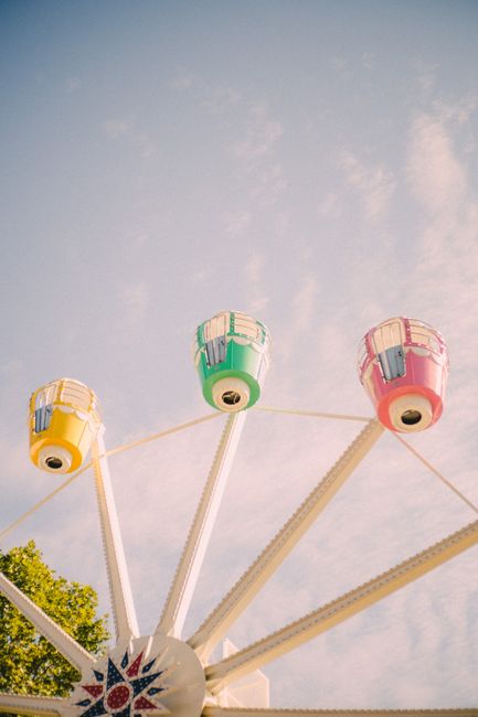 Brightly colored Ferris wheel against a clear sky at a funfair, offering a cheerful vibe.