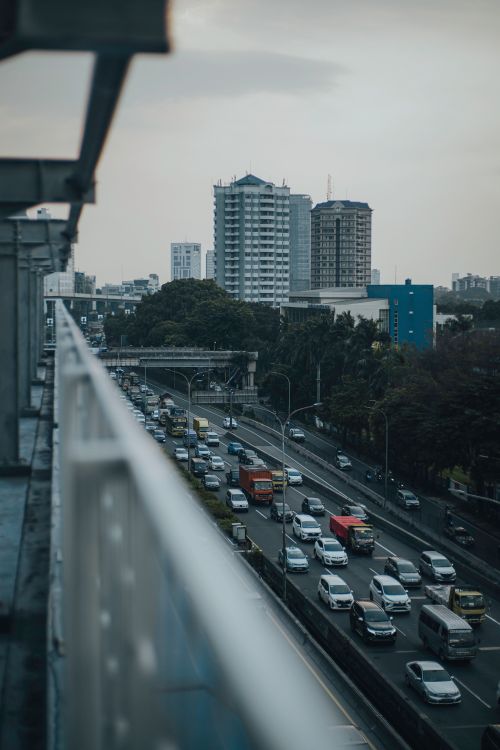 Free A bustling urban street with heavy traffic and towering city buildings in an overcast setting. Stock Photo