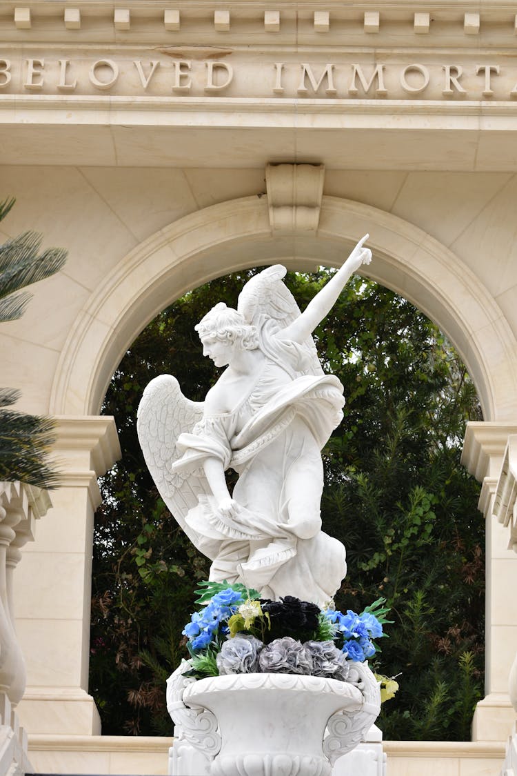 Photo Of A White Angel Statue Against An Arch