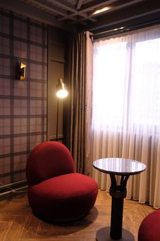 Stylish interior featuring a red chair, floor lamp, and elegant decor.