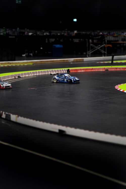Free Thrilling model car race on a curving track with blurred motion in an indoor setting. Stock Photo