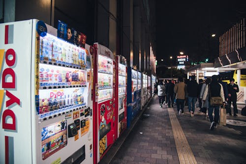 People Walking on Sidewalk at Nighttime