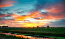 爱达荷州宁静的农田上，笼罩着一片色彩鲜艳、令人惊叹的日落，捕捉到了乡村的静谧美景