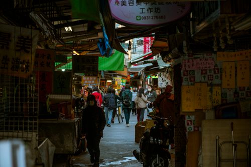 Free Vibrant urban scene capturing pedestrians walking through a lively Asian market alleyway. Stock Photo