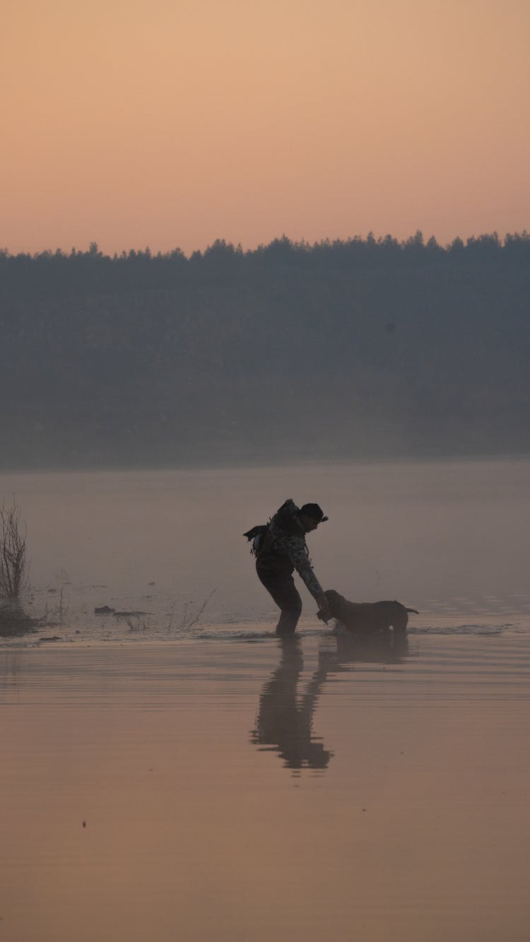 A Man With A Dog In Water 