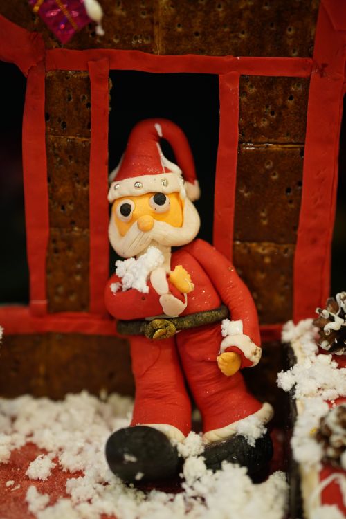 Free Close-up of a Santa Claus doll with faux snow, perfect for a festive holiday theme. Stock Photo