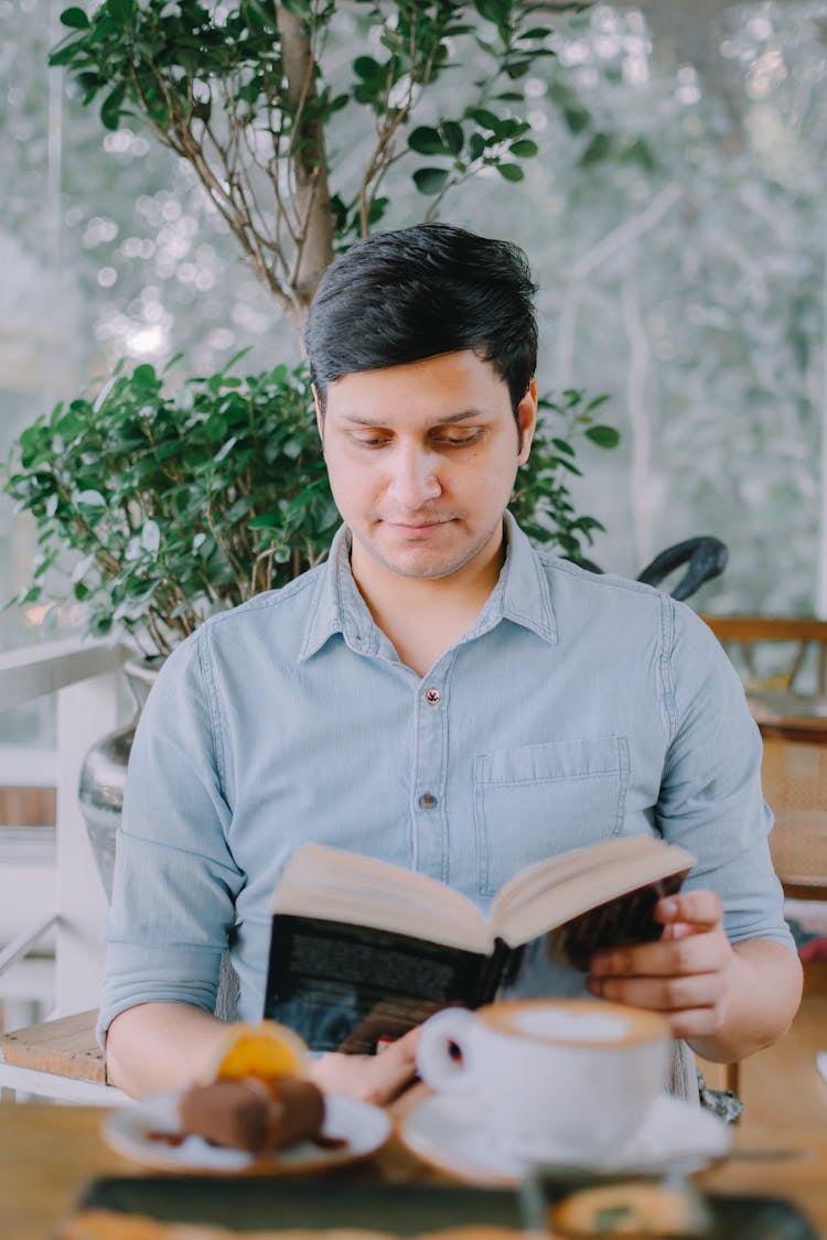 Man Sitting And Reading Book