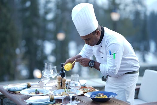 A chef skillfully prepares dishes for a stunning outdoor dining experience, showcasing food artistry.